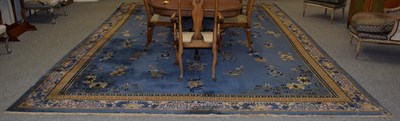 Lot 1126 - A carpet of Chinese design, the pale indigo field with Taoist motifs, centred by an indigo...