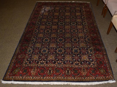 Lot 1128 - North West Persian carpet, the midnight blue field of geometic devices enclosed by strawberry...