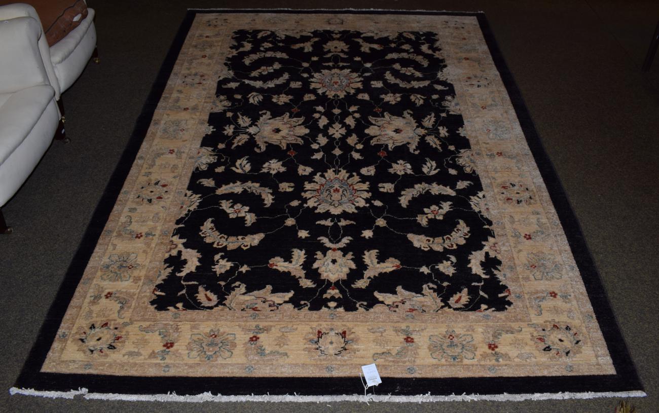 Lot 1131 - Ziegler design rug, the charcoal field of leafy vines and palmettes enclosed by ivory borders,...