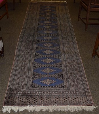 Lot 1135 - Lahore Bukhara runner, the compartmentalised field of guls enclosed by multiple borders, 300cm...