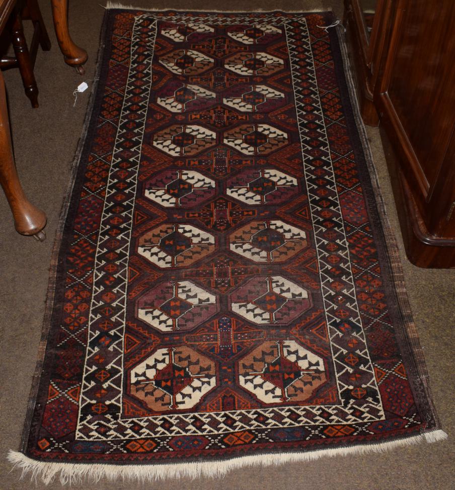 Lot 1139 - Baluch rug, the aubergine field with two columns of quartered güls enclosed by bird borders, 200cm