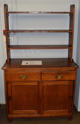 Lot 1151 - An early 20th century Arts and Crafts style oak cupboard, fitted with a plate rack