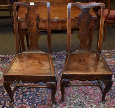 Lot 1196 - A pair of George II oak panel seated chairs with urn carved splats