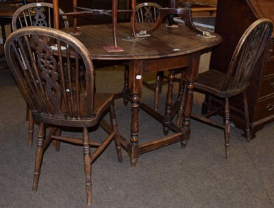 Lot 1227 - An oak gateleg table on baluster turned legs; together with a set of four wheel back chairs (5)