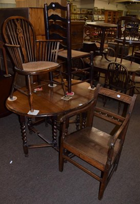 Lot 1236 - An oak drop leaf dining table; a Georgian armchair; a cane seated beech armchair; and a ash...
