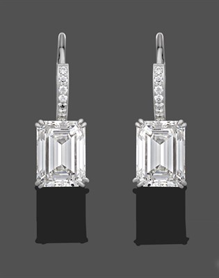 Lot 1127 - A Pair of Diamond Drop Earrings, an emerald-cut diamond in a white double claw setting...