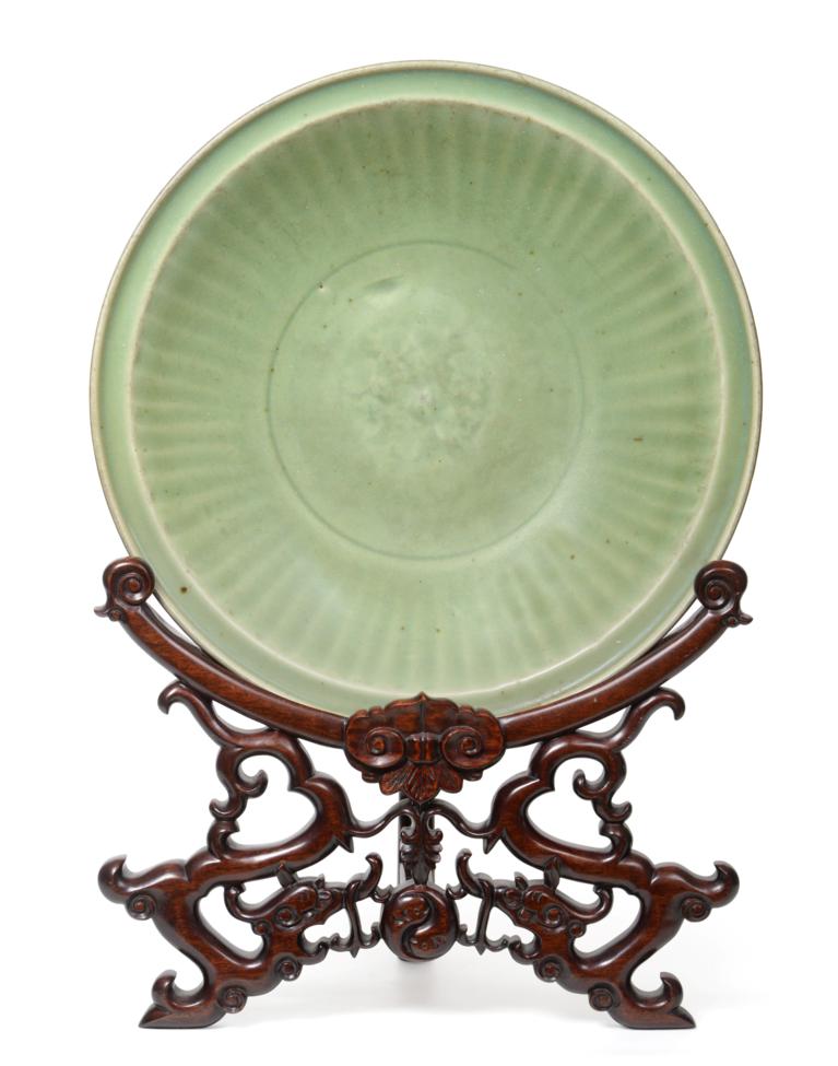 Lot 30 - A Longquan Celadon Dish, Ming dynasty, carved with a central foliate panel within a broad...
