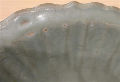 Lot 31 - A Longquan Celadon Dish, Ming dynasty, carved with lattice and scrolls within an Arabesque...