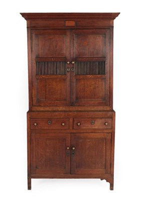 Lot 280 - A George III Joined Oak Food Cupboard, the bold and dentil cornice above two cupboard doors...