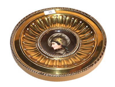Lot 35 - A late 19th/early 20th century brass comport with a circular porcelain panel