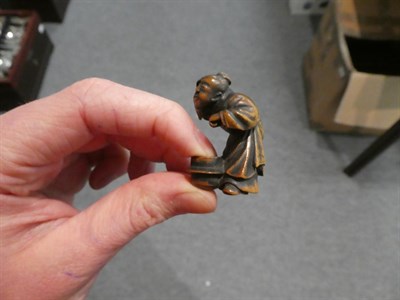 Lot 65 - A Japanese wood netsuke, 19th century, as a crouching figure peering into a brazier, signed,...