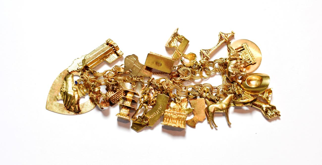 Lot 79 - A gold charm bracelet, stamped '14K', hung with various charms including an elephant, a hat, a...