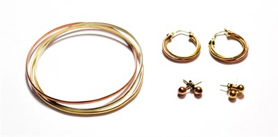Lot 90 - A 9 carat tri-colour gold triple band bangle; a pair of hoop earrings, stamped '375'; and two pairs