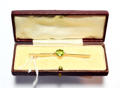 Lot 102 - An early twentieth century peridot and seed pearl brooch, an oval cut peridot in a claw...