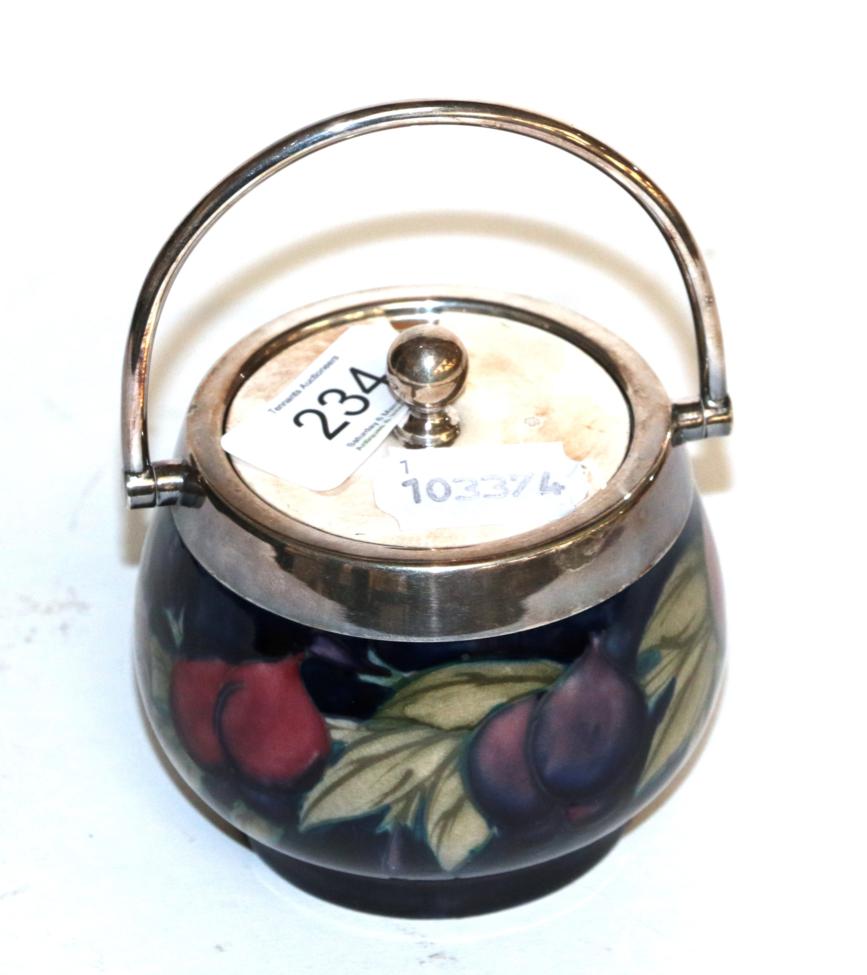 Lot 234 - A William Moorcroft 'Wisteria' pattern preserve pot, with silver plated rim, swing handle and...