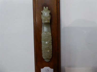 Lot 289 - A Chinese jade belt hook, carved with mythical beast head, mounted on hardwood plinth;  with...