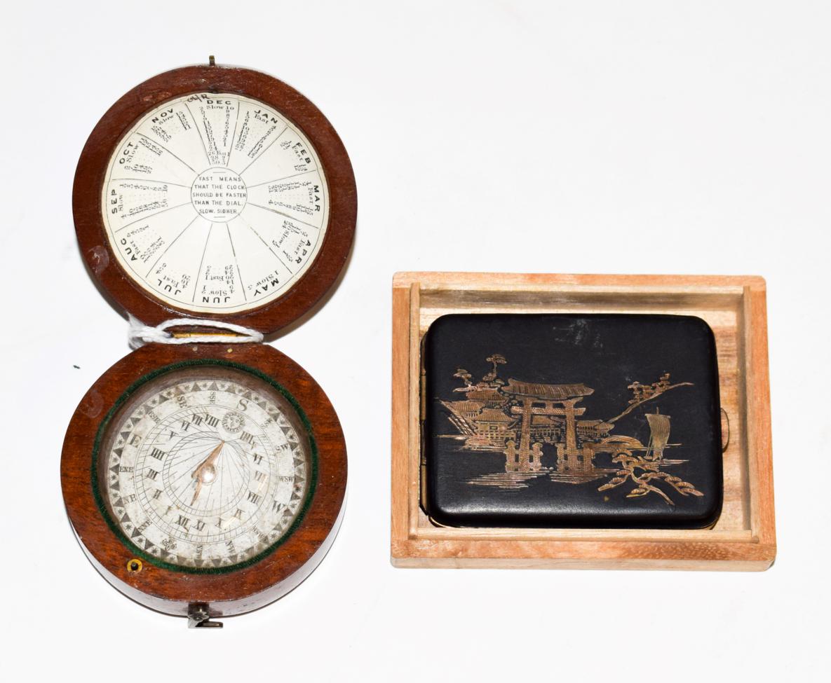 Lot 295 - A 19th century cased pocket compass/sundial and Japanese metalwork matchcase, in wooden box (2)