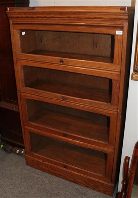 Lot 1209 - An early 20th century oak four piece sectional bookcase, 87cm wide