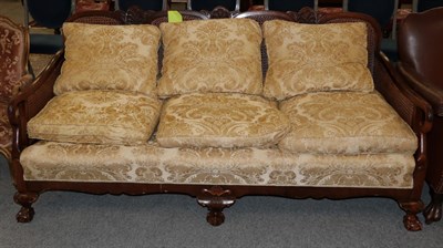 Lot 1255 - An early 20th century double caned three seater bergere sofa, 180cm wide