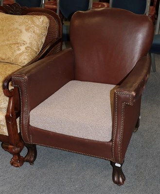 Lot 1256 - An early 20th century tub chair covered in brown close nailed leather