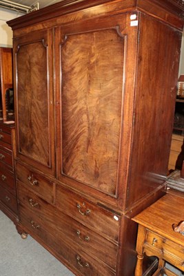 Lot 1292 - A late George III mahogany linen press, the upper section with sliding trays, 126cm wide