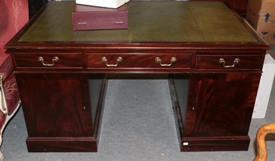 Lot 1323 - A reproduction mahogany desk with green leather writing surface, 145cm wide