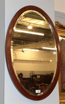 Lot 1328 - A reproduction cream painted mirror in the Victorian style; and an oval bevelled glass mirror (2)