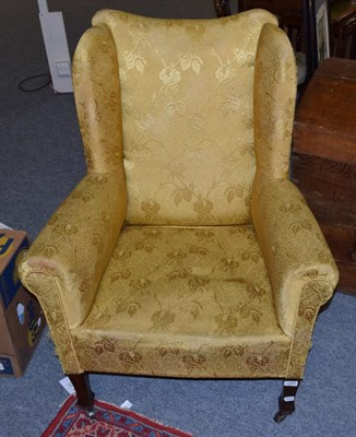 Lot 1344 - A late 19th century wing back chair upholstered in yellow fabric