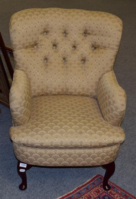 Lot 1345 - A modern button back armchair upholstered in gold and floral fabric