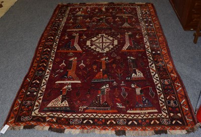 Lot 1347 - A Kashgai rug, the aubergine field with columns of dancing ladies around a stepped medallion,...