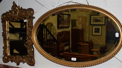 Lot 1360 - A carved giltwood mirror; and an oval mirror (2)