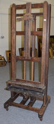 Lot 1381 - A late 19th/early 20th century large adjustable easel with castors, base measures 81cm wide