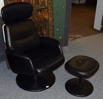 Lot 1382 - A modern black swivel chair and footstool