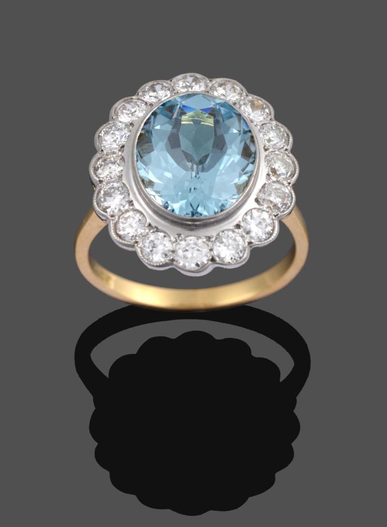 Lot 1017 - An Aquamarine and Diamond Cluster Ring, the oval cut aquamarine in a white rubbed over setting,...