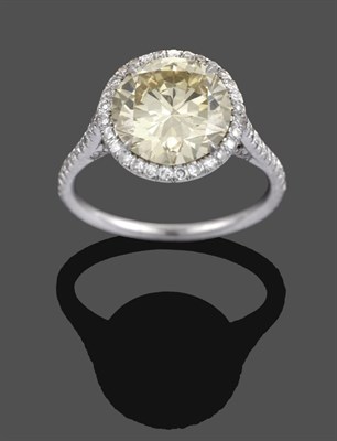 Lot 1018 - A Diamond Cluster Ring, a fancy intense yellow round brilliant cut diamond within a border of white