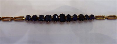 Lot 1023 - A Sapphire Bracelet, eleven graduated oval cut and cushion cut sapphires centrally terminating...