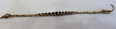 Lot 1023 - A Sapphire Bracelet, eleven graduated oval cut and cushion cut sapphires centrally terminating...