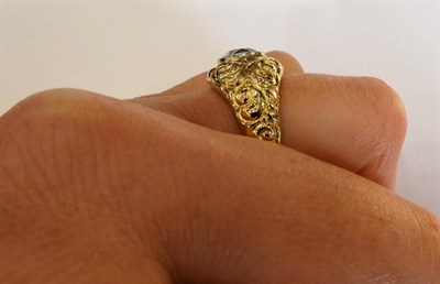 Lot 1040 - A Diamond Solitaire Ring, the old cut diamond in a yellow millegrain setting to a floral chased...