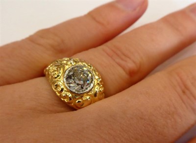 Lot 1040 - A Diamond Solitaire Ring, the old cut diamond in a yellow millegrain setting to a floral chased...