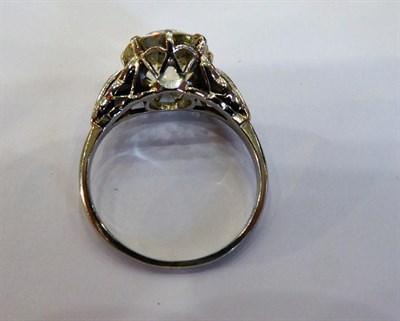 Lot 1055 - A Diamond Solitaire Ring, the old cut diamond in a white claw setting, to fancy panelled...