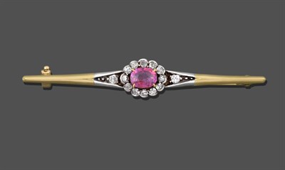 Lot 1062 - A Ruby and Diamond Bar Brooch, an oval cut ruby in a yellow claw setting within a border of old cut