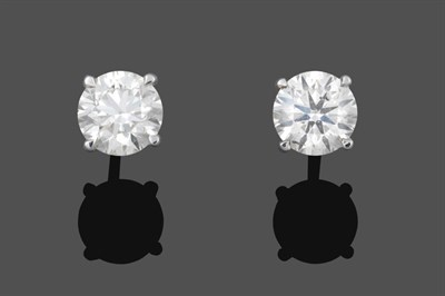 Lot 1073 - A Pair of 18 Carat White Gold Diamond Solitaire Earrings, the round brilliant cut diamonds in...