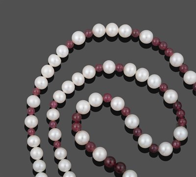 Lot 1076 - A Ruby and Cultured Pearl Necklace, smooth ruby beads spaced by groups of cultured pearls,...