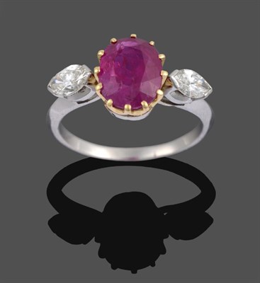 Lot 1080 - A Ruby and Diamond Three Stone Ring, the oval cut ruby in a yellow claw setting sits between...