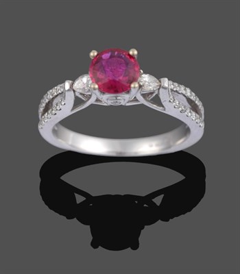 Lot 1086 - An 18 Carat White Gold Ruby and Diamond Ring, the round cut ruby with a round brilliant cut diamond