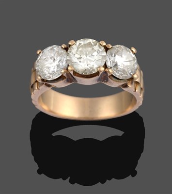 Lot 1097 - A Diamond Three Stone Ring, the graduated round brilliant cut diamonds in yellow claw settings,...
