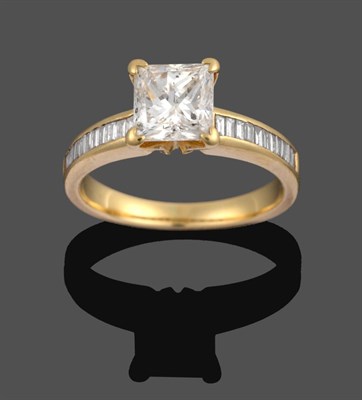 Lot 1098 - A Diamond Solitaire Ring, the princess cut diamond in a yellow four claw setting, to baguette...