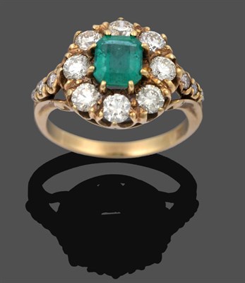 Lot 1106 - An Emerald and Diamond Cluster Ring, the emerald-cut emerald within a border of round brilliant cut