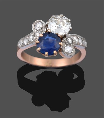 Lot 1109 - A Sapphire and Diamond Crossover Ring, the old cut diamond and round cut sapphire, in white...