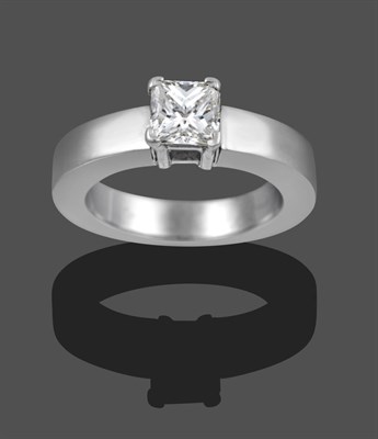 Lot 1129 - A Diamond Solitaire Ring, the princess cut diamond in a white four claw setting on a plain polished